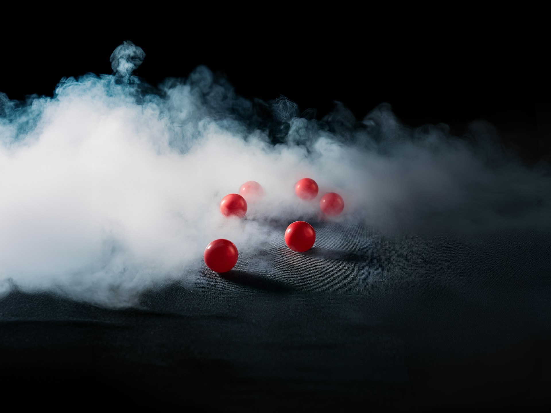 A group of red balls floating in a cloud of smoke